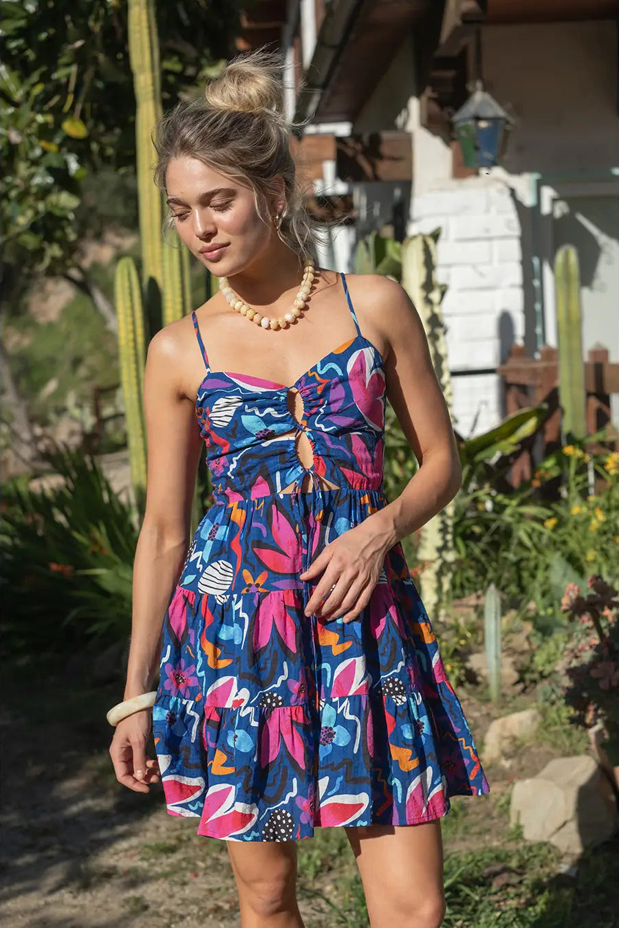 Woman wearing a colorful dress with a garden background