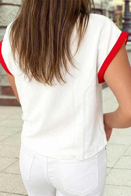 Person wearing a white shirt with red trim outdoors
