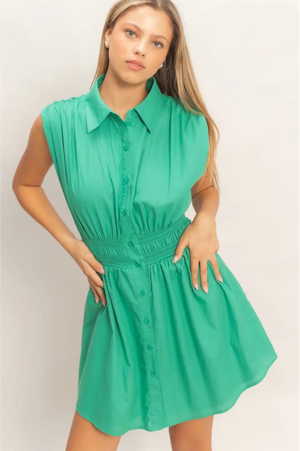 Woman wearing a green dress against a plain background