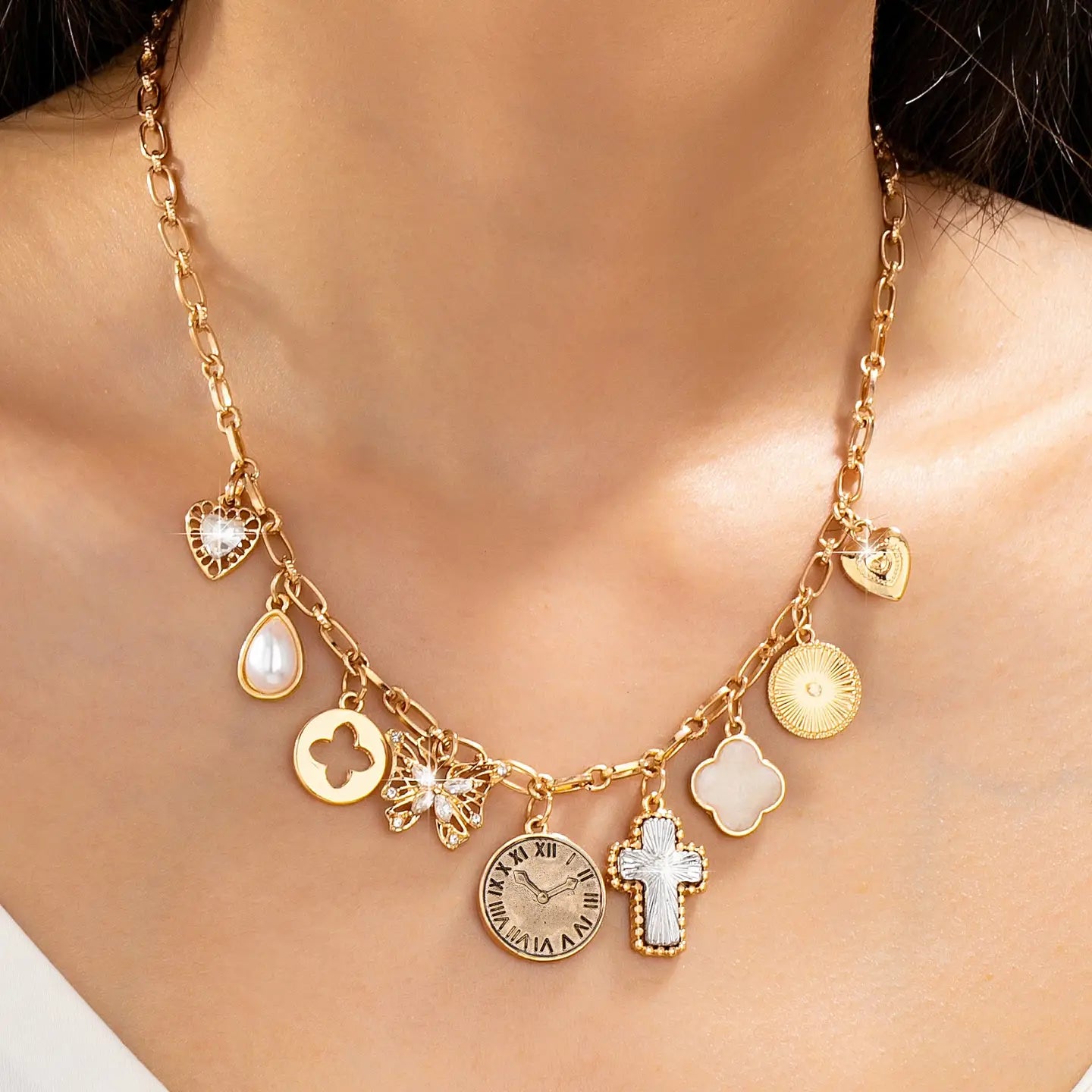 Gold necklace with various charms on a person's neck