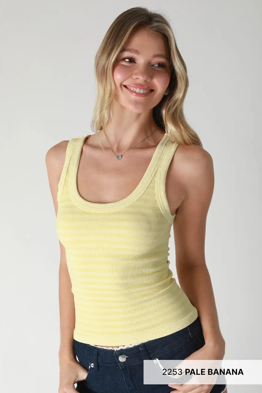 Woman wearing a yellow tank top with text '2253 PALE BANANA' at the bottom.