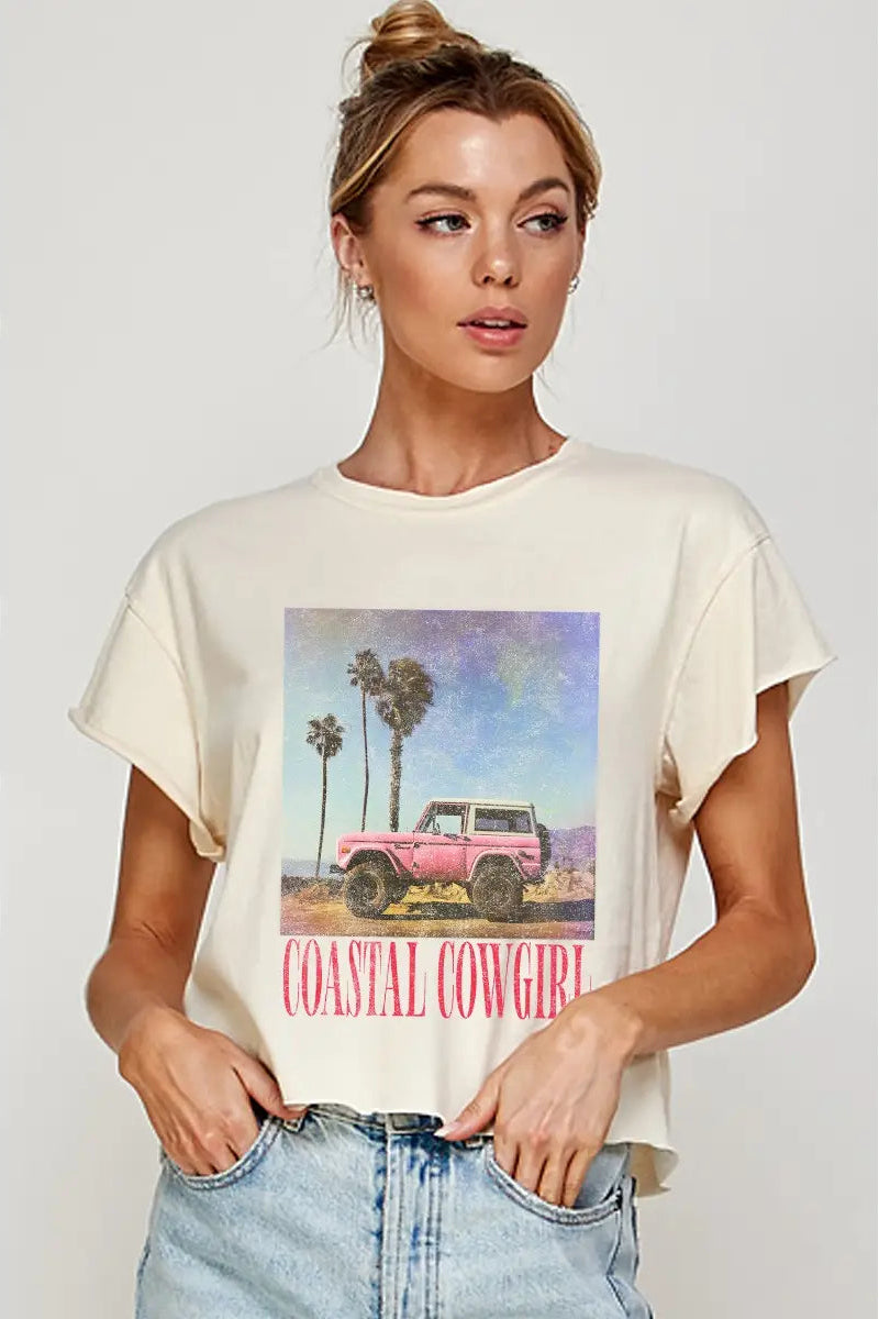 Woman wearing a white t-shirt with a graphic design and text, standing against a plain background.