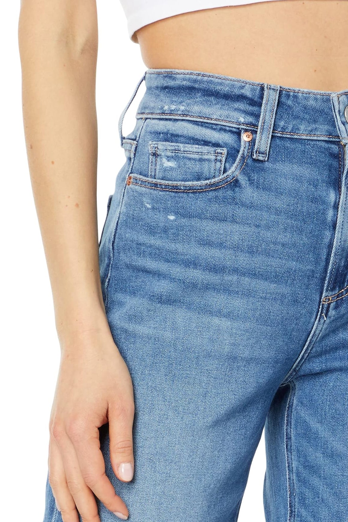 Close-up of blue jeans worn by a person on a white background
