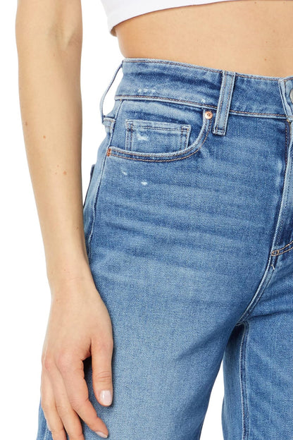 Close-up of blue jeans worn by a person on a white background