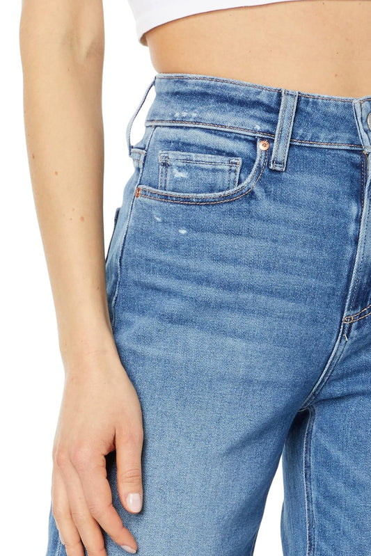 Close-up of blue jeans worn by a person on a white background