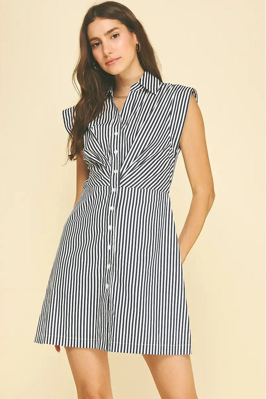 Woman wearing a black and white striped dress on a beige background