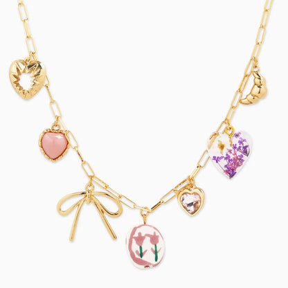 Gold necklace with heart and bow-shaped pendants on a white background