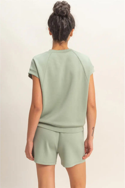 Woman wearing a light green outfit on a beige background