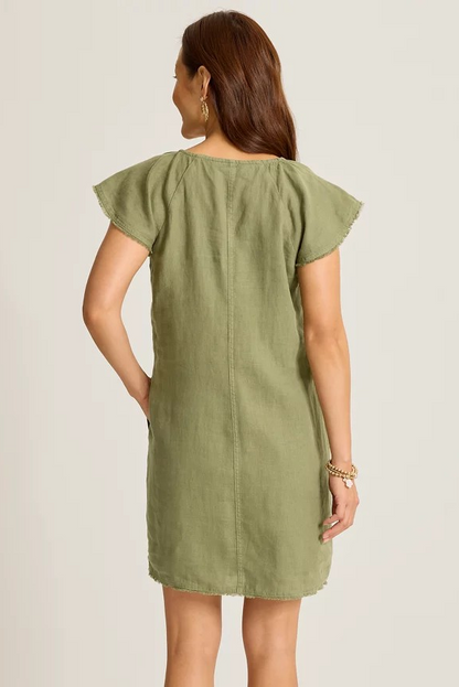 Woman wearing a green dress against a plain background