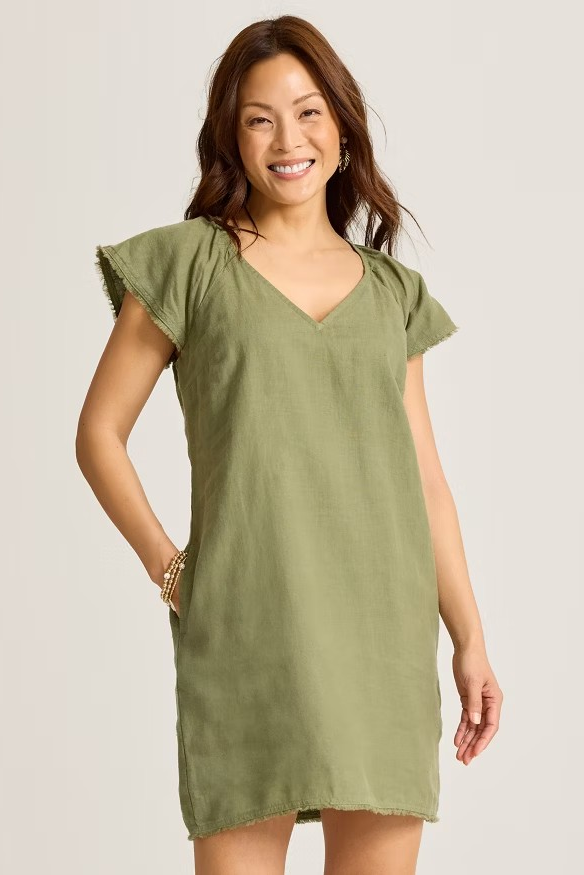 Woman wearing a green dress against a plain background