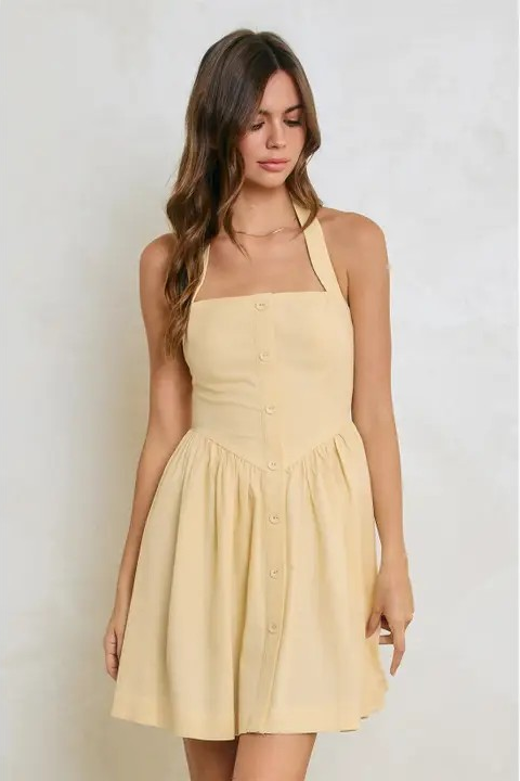 Woman wearing a yellow dress against a plain background