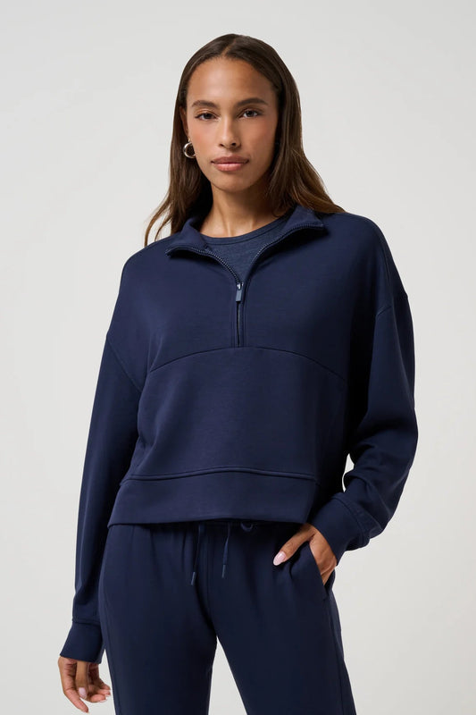 woman wearing navy blue half zip sweatshirt with navy pants