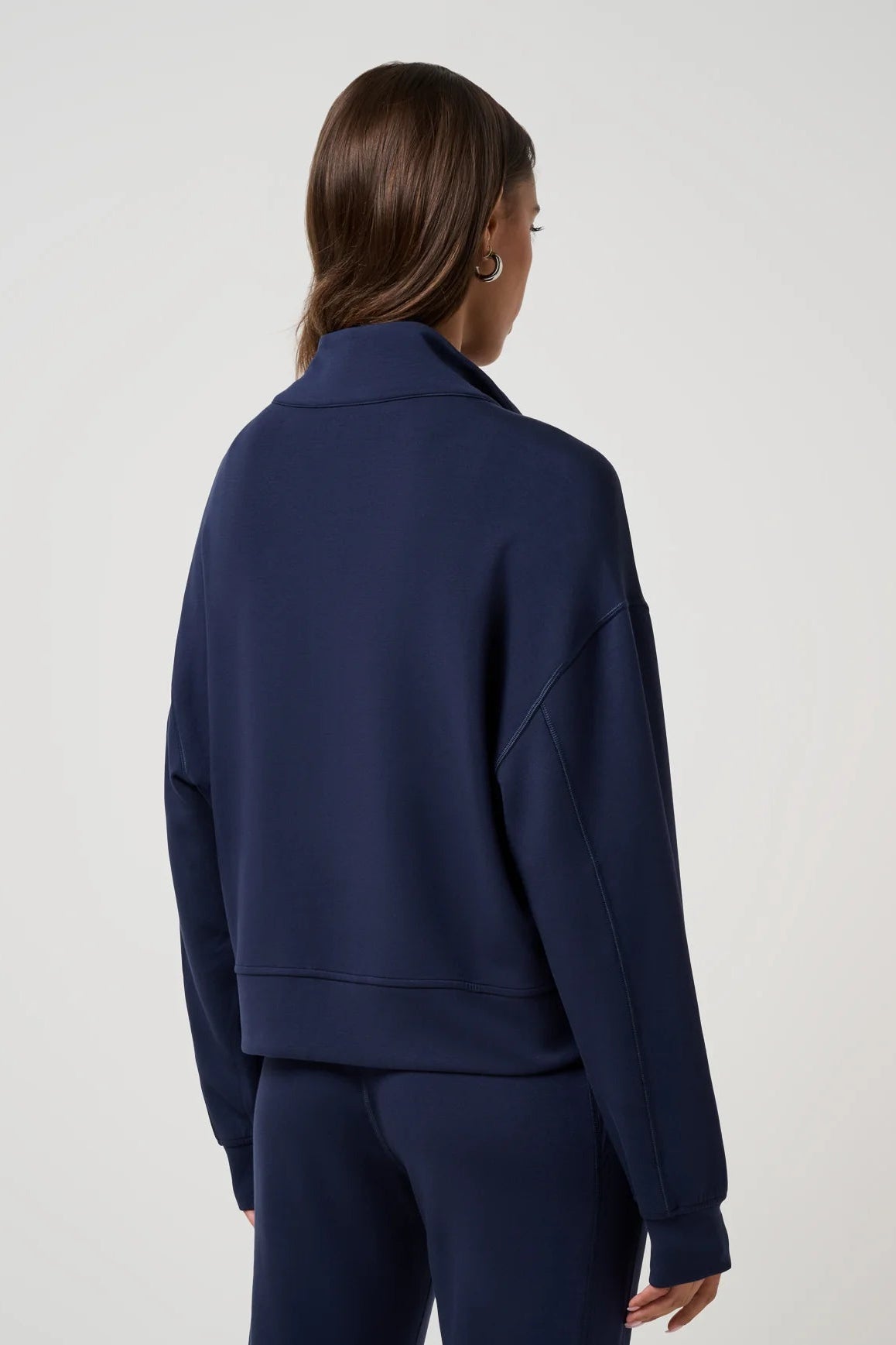 woman wearing navy blue half zip sweatshirt with navy pants
