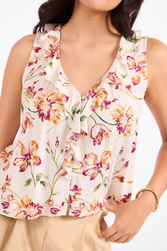 Woman wearing a floral sleeveless top with a plain background