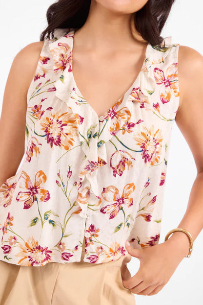 Woman wearing a floral sleeveless top with a plain background