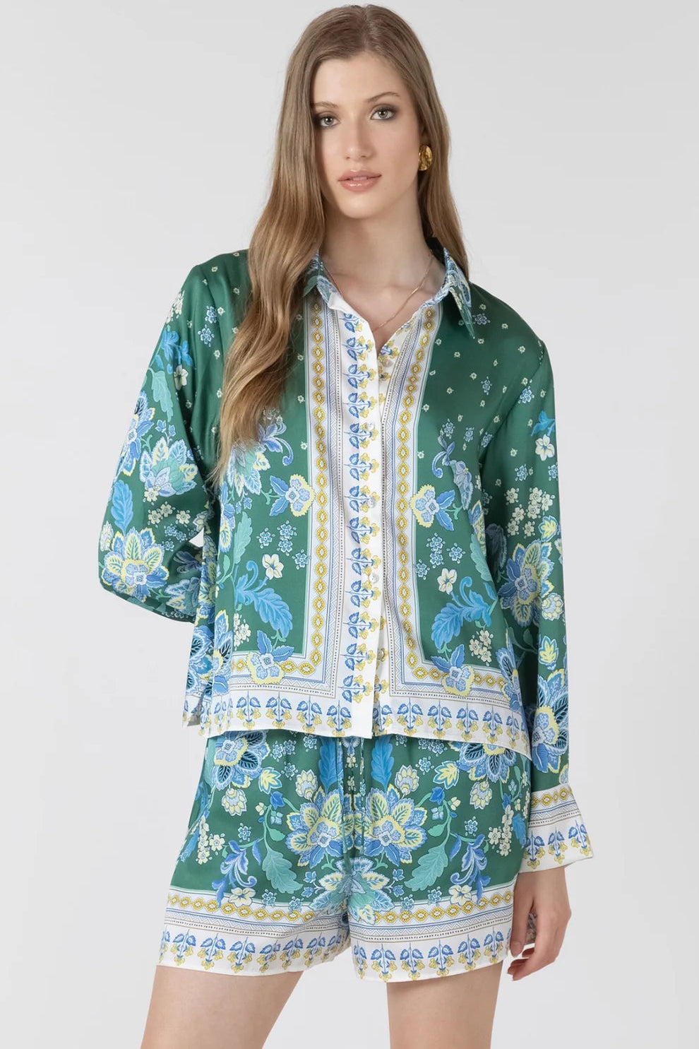 Woman wearing a green floral outfit on a white background