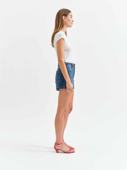 Woman wearing a white top and blue denim skirt on a white background