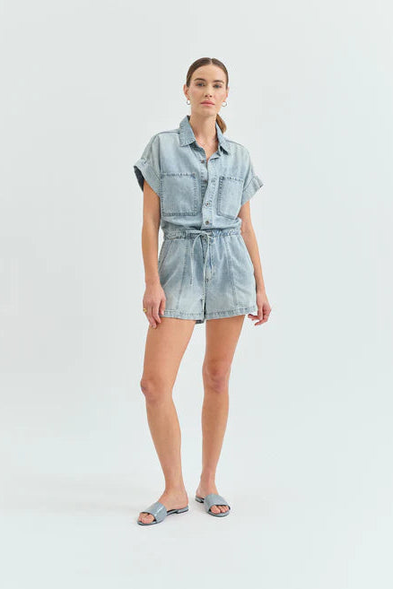 Woman wearing a light denim dress on a white background