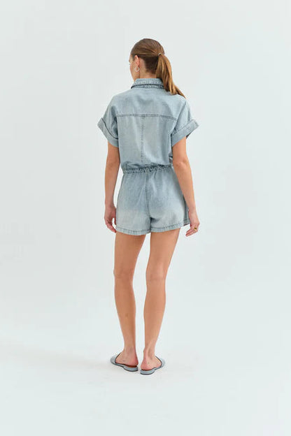 Woman wearing a denim romper on a white background