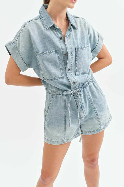Light blue denim romper worn by a person on a white background