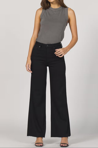 Person wearing a gray sleeveless top and black wide-leg pants on a plain background