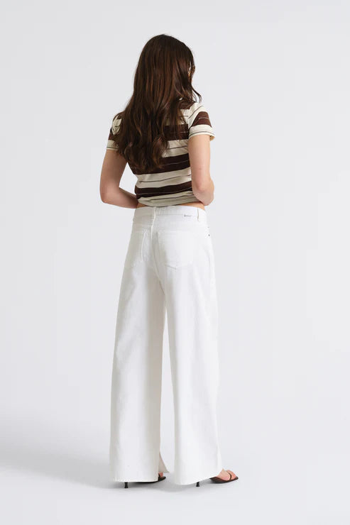 Person wearing a striped shirt and white wide-leg pants on a white background