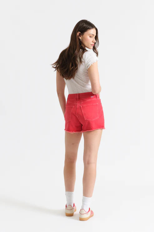 Woman wearing red shorts and a white top on a white background