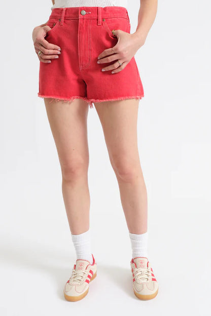 Person wearing red denim shorts on a white background