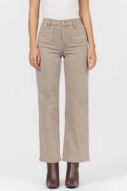 A model wearing a pair of light beige straight-leg jeans with brown ankle boots, shown from the waist down against a plain white studio background.