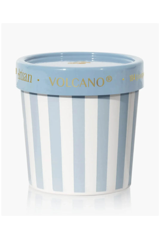Candle in a striped pot with 'Volcano' branding on a white background