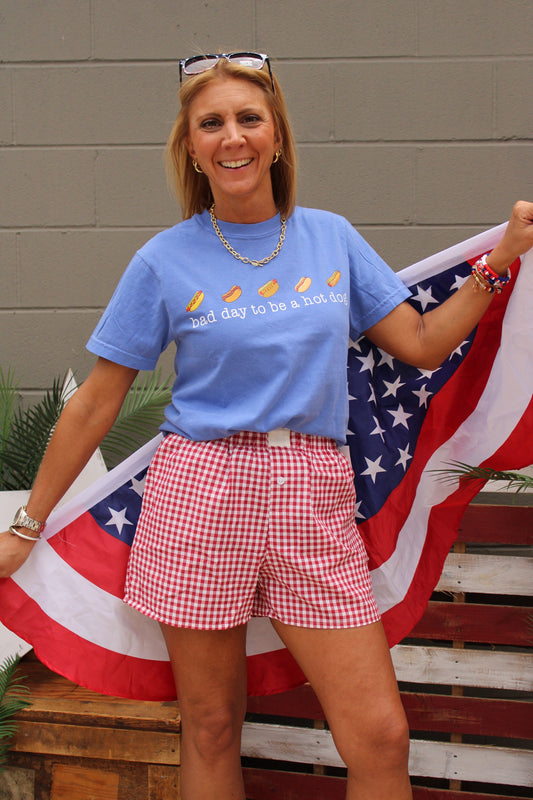 woman wearing hot dog tee with red checked shorts