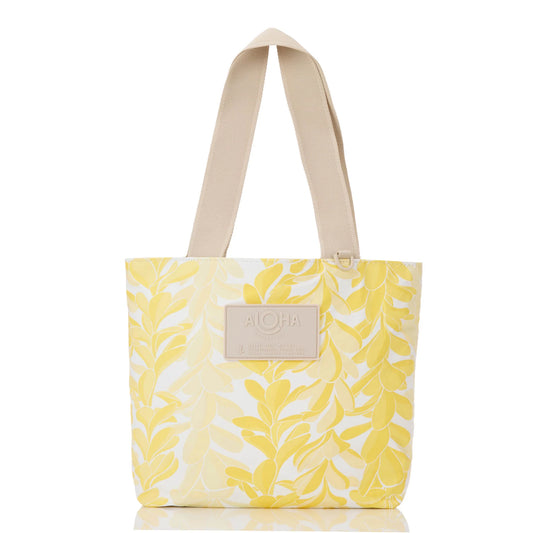 Yellow tote bag with leaf pattern and 'Aloha' label on a white background