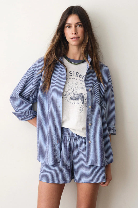woman wearing striped blue button down with matching shorts with tee underneath