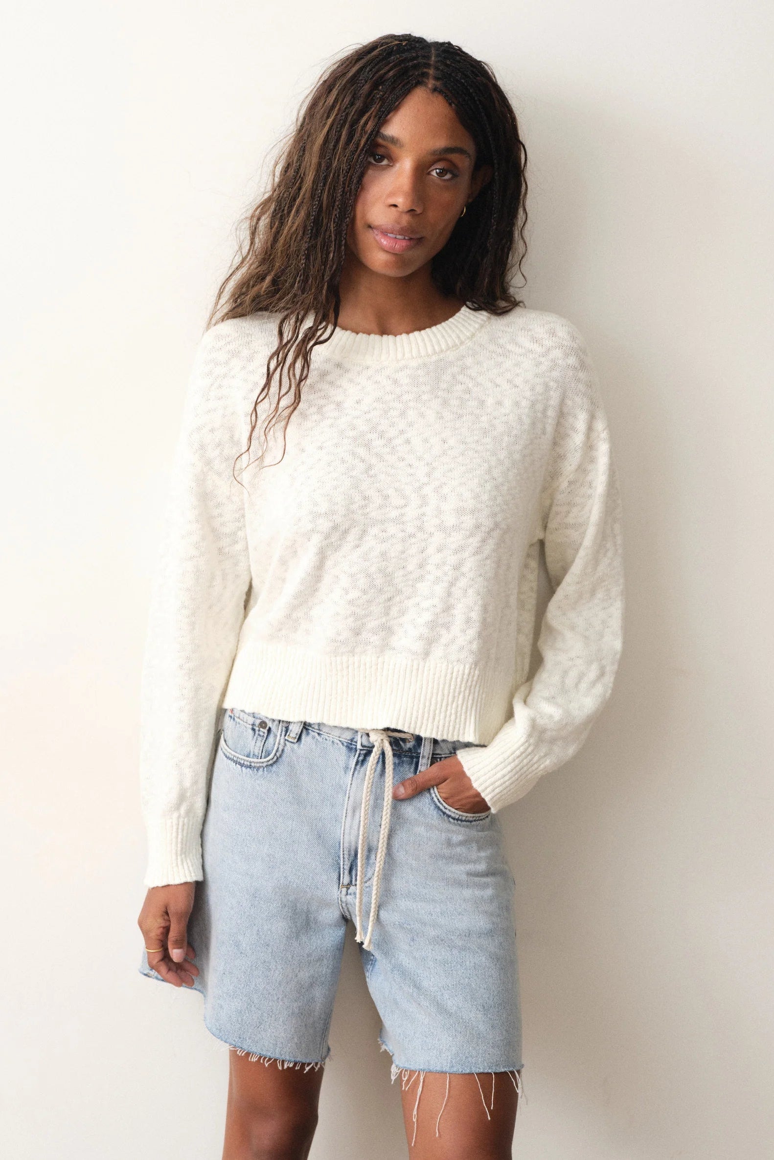 woman wearing white sweater with jean shorts