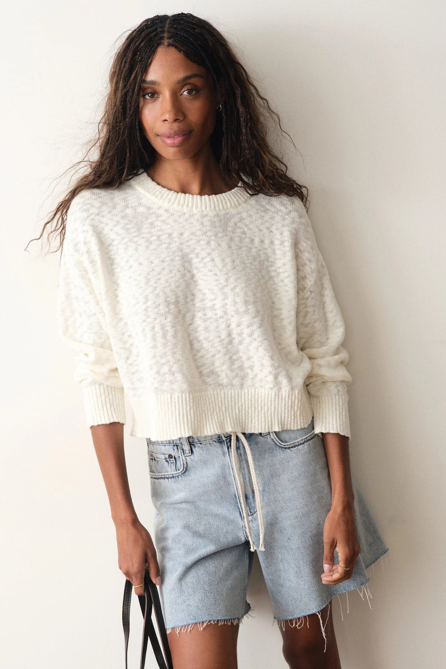 woman wearing white sweater with jean shorts

