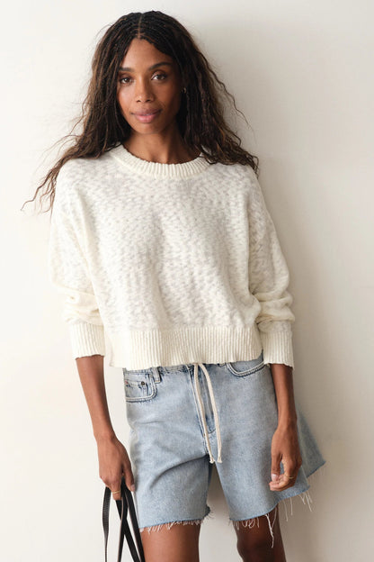 woman wearing white sweater with jean shorts
