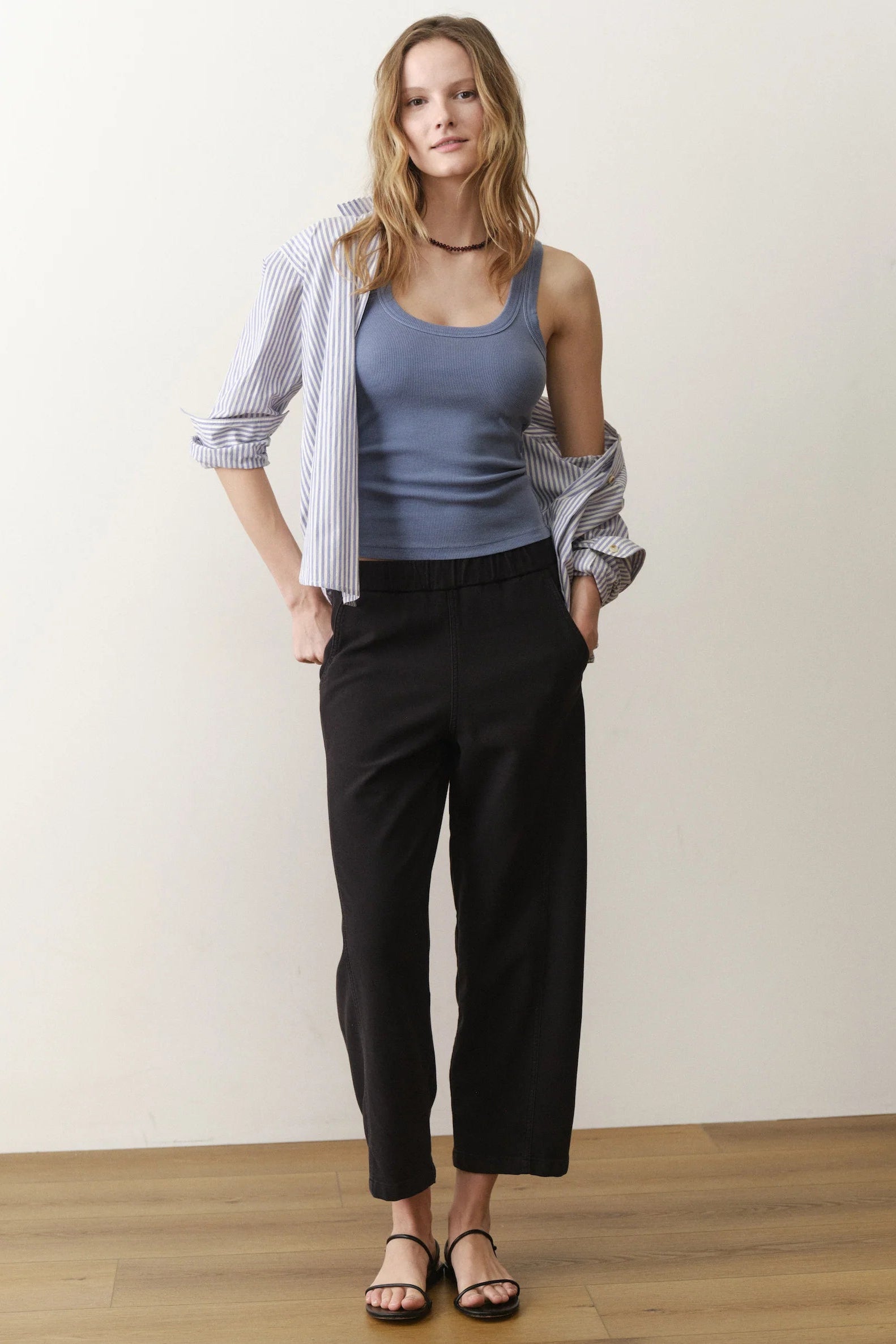 woman wearing blue tank with black pants