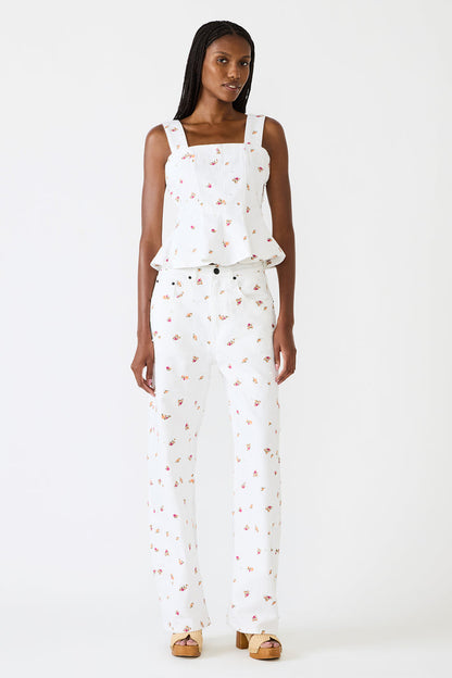 Woman wearing a white floral jumpsuit on a white background