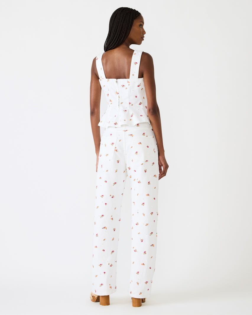 Woman wearing a white dress with a subtle pattern on a white background