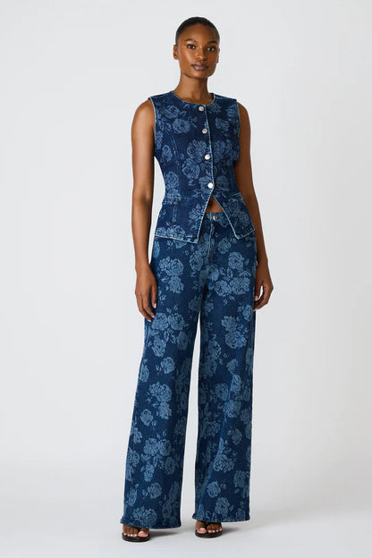 Woman wearing a blue floral jumpsuit on a white background