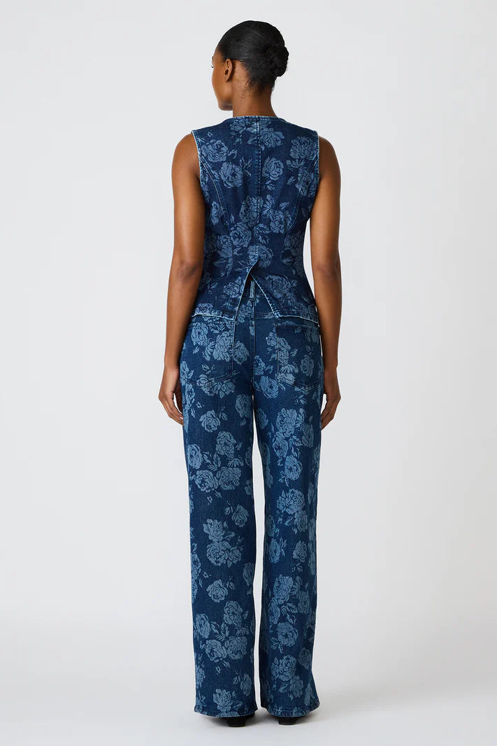 Woman wearing a blue floral jumpsuit on a white background