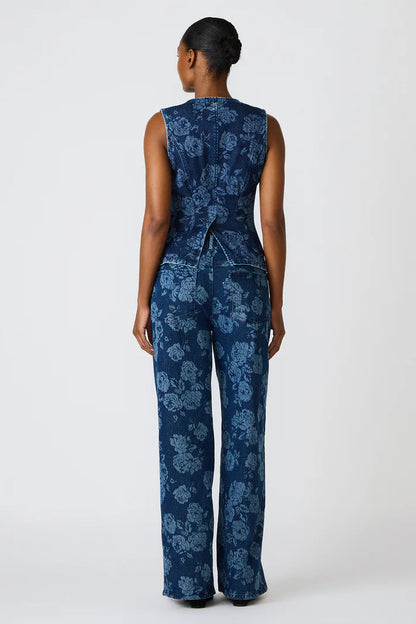 Woman wearing a blue floral jumpsuit on a white background