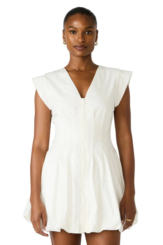 Woman wearing a white dress with ruffled sleeves on a white background