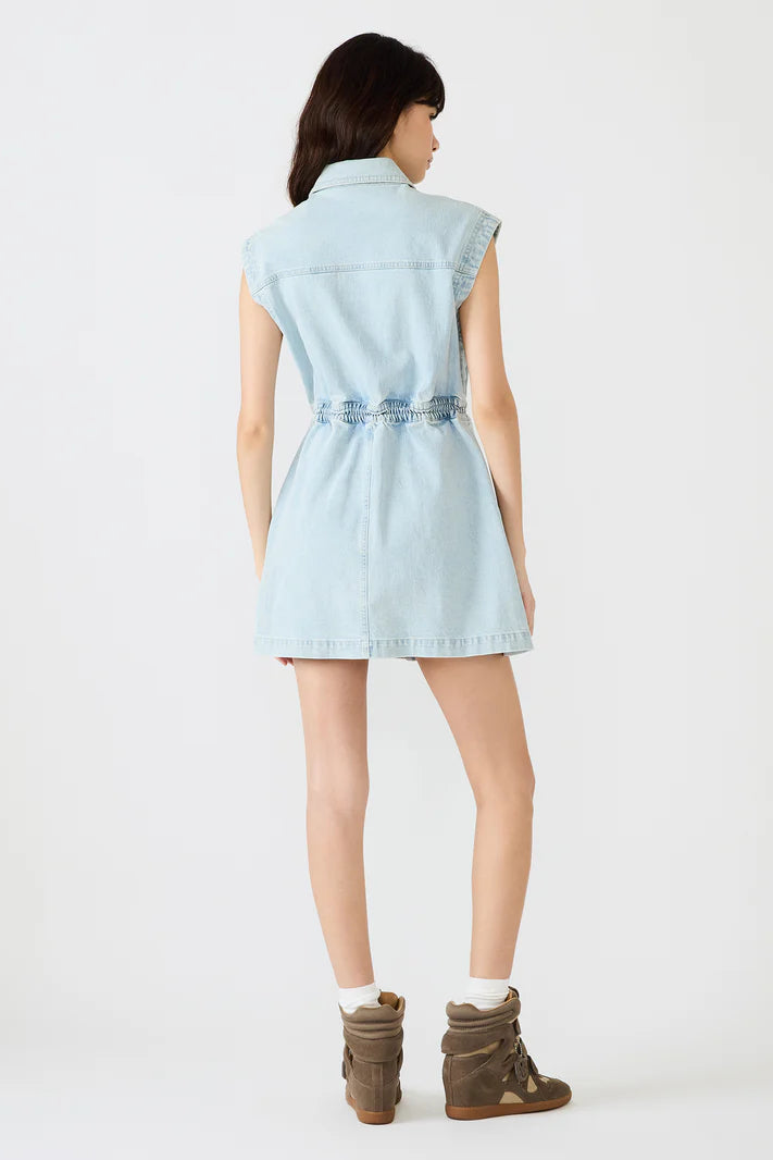 Woman wearing a light blue denim dress on a white background