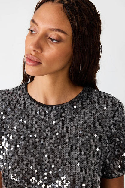 woman wearing sequin top with black pants