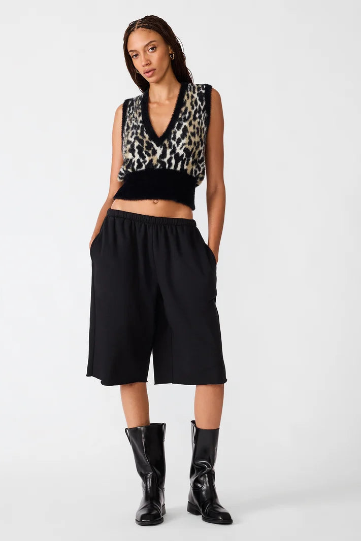 woman wearing leoprard print vest with black pants and boots