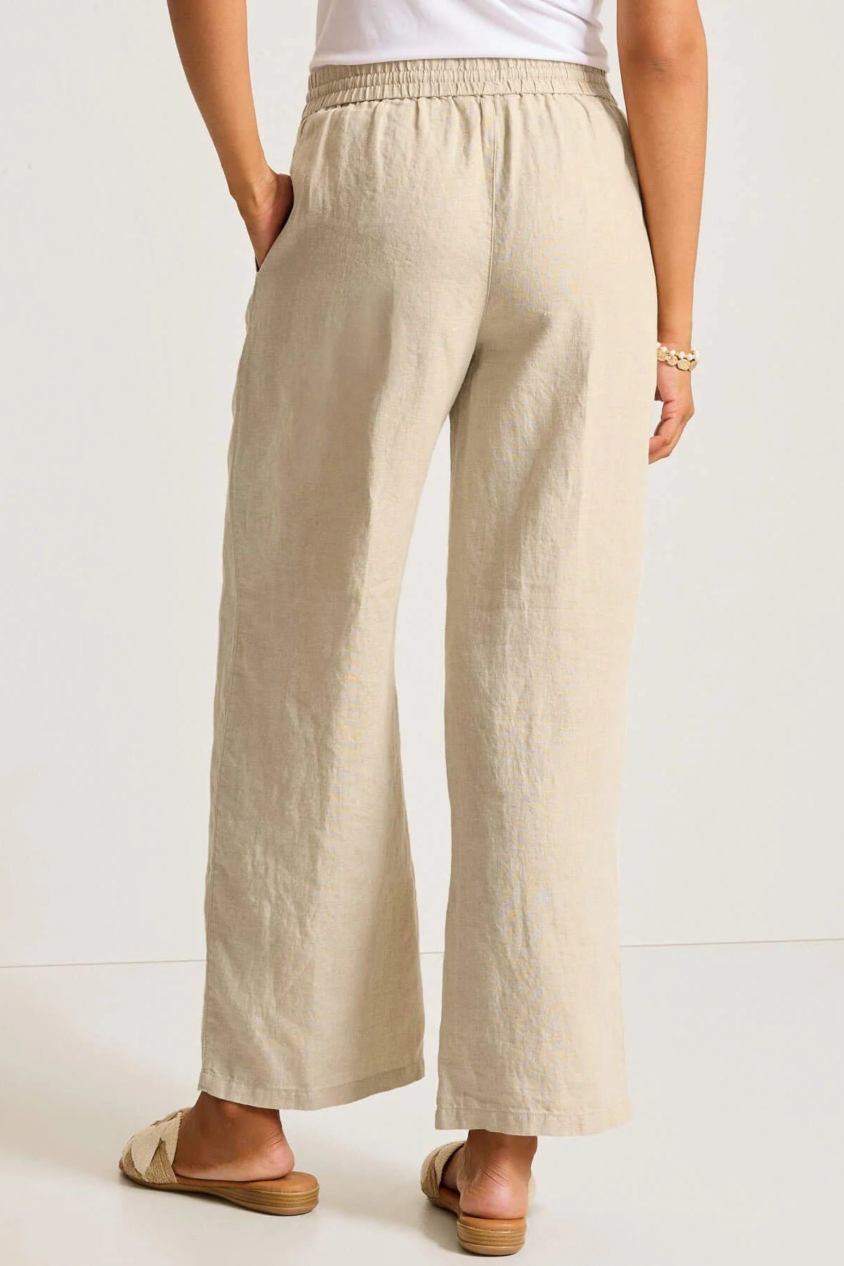 Beige wide-leg pants worn by a person on a white background