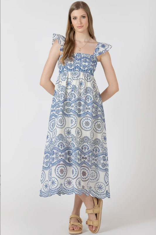Woman wearing a blue and white patterned dress on a white background
