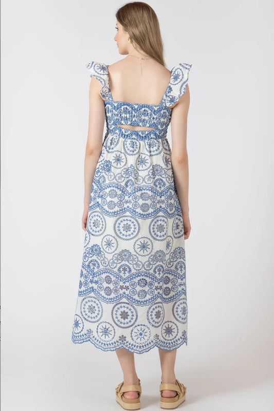 Woman wearing a blue and white patterned dress on a white background