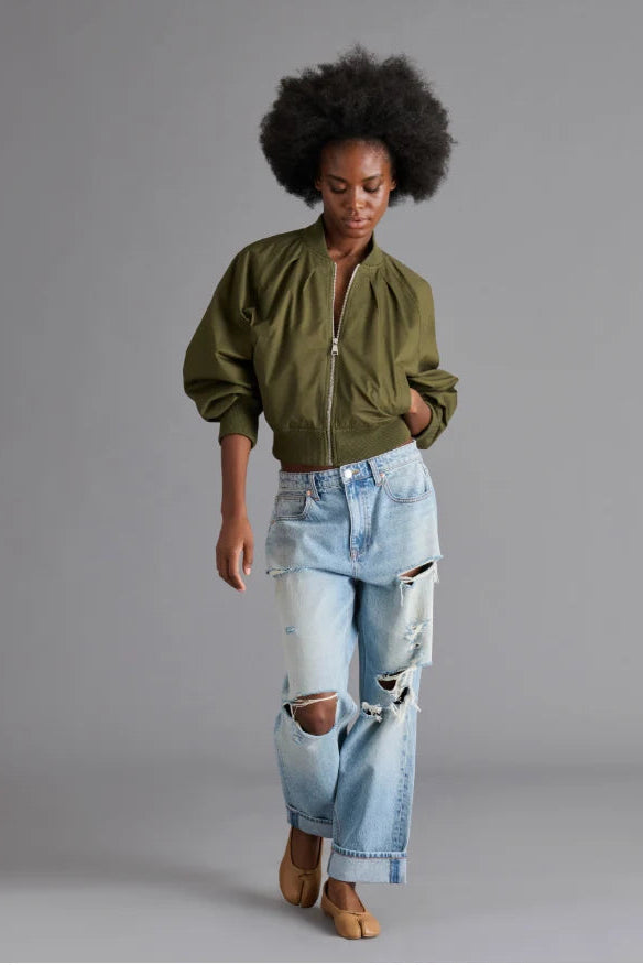 woman wearing green jacket and jeans